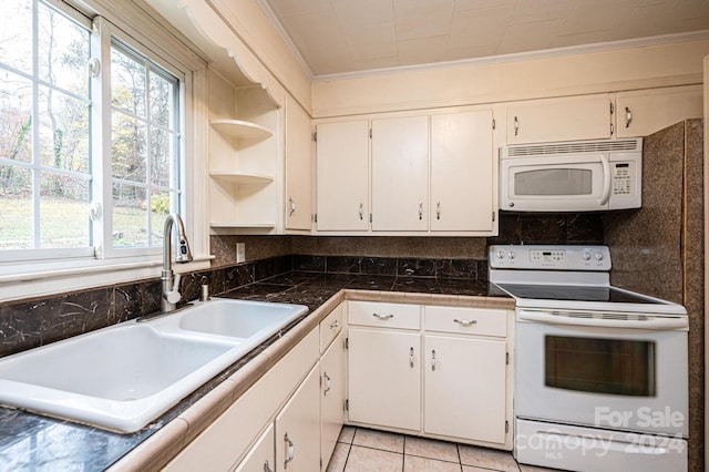 kitchen with light tile patterned floors, white appliances, white cabinetry, and sink