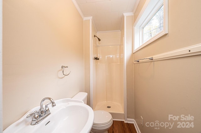 bathroom with a shower, wood-type flooring, ornamental molding, and sink