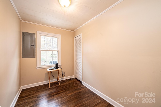 spare room with electric panel, dark wood-type flooring, and ornamental molding