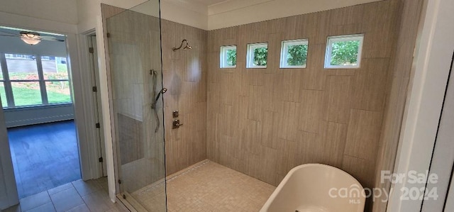 bathroom with tile patterned floors, a healthy amount of sunlight, and separate shower and tub