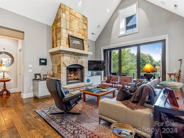 22 Foxbridge Way, Arden, NC 28704 - living room with high vaulted ceiling, dark wood-style flooring, a stone fireplace, and baseboards