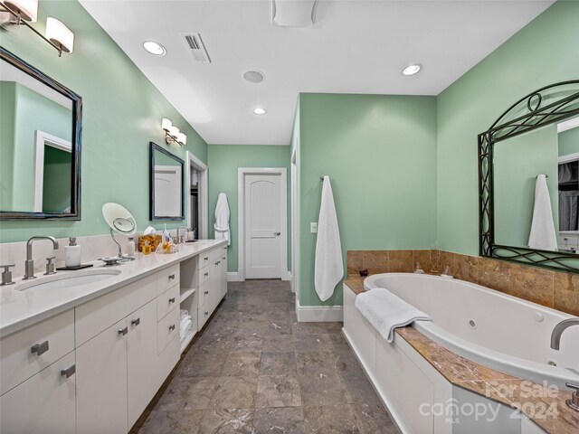 22 Foxbridge Way, Arden, NC 28704 - full bathroom featuring baseboards, a jetted tub, stone finish floors, double vanity, and recessed lighting