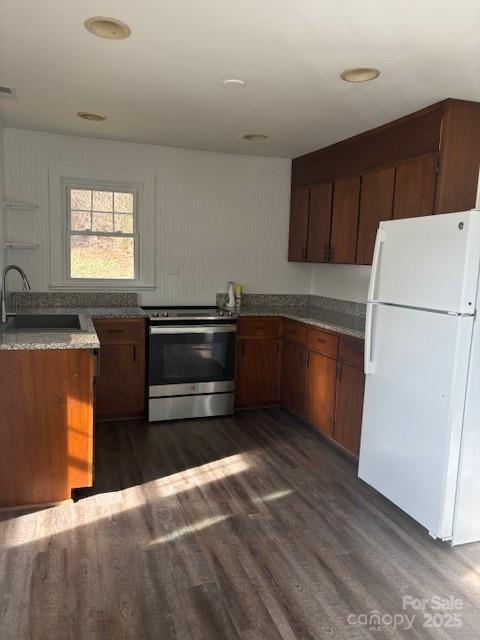 kitchen featuring a sink, dark wood-style flooring, stainless steel range with electric cooktop, and freestanding refrigerator