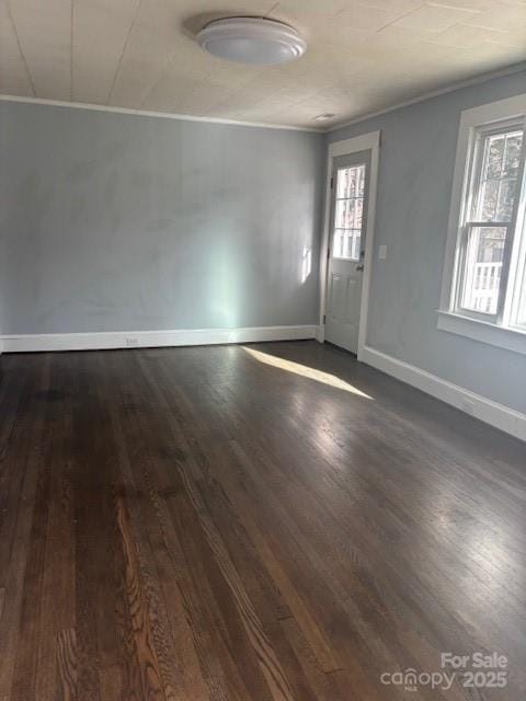 interior space with crown molding, dark wood finished floors, and baseboards