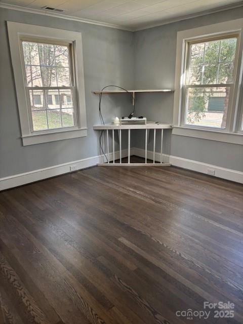 unfurnished office featuring ornamental molding, dark wood finished floors, visible vents, and baseboards