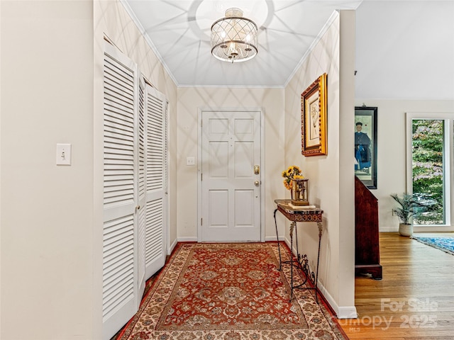 interior space featuring a notable chandelier, crown molding, and hardwood / wood-style flooring