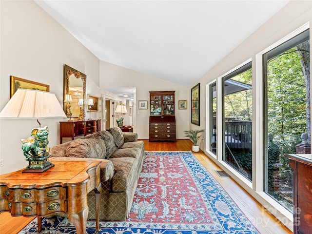 living room featuring light hardwood / wood-style flooring and vaulted ceiling