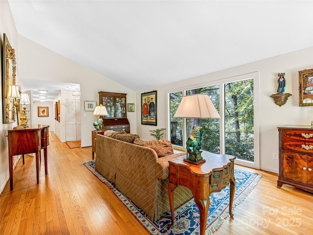 living room featuring vaulted ceiling and light hardwood / wood-style flooring