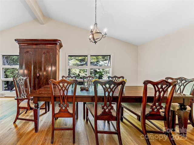 dining area with light hardwood / wood-style flooring, lofted ceiling with beams, and an inviting chandelier