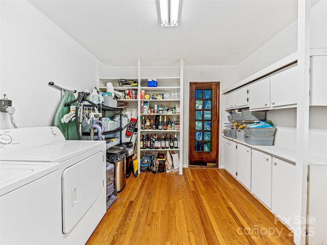 clothes washing area with cabinets, light hardwood / wood-style flooring, and independent washer and dryer