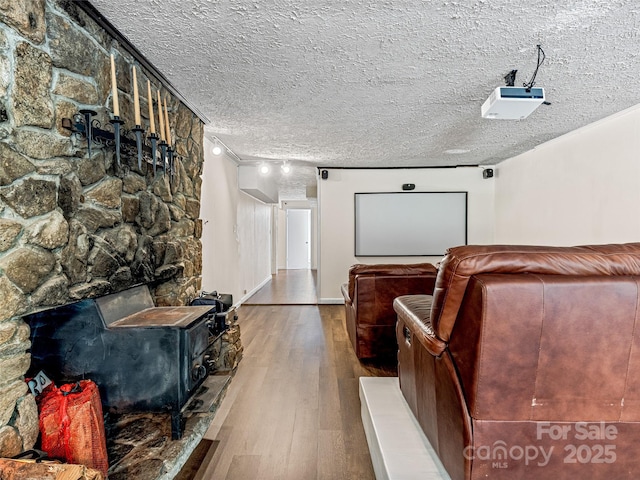 cinema with hardwood / wood-style floors, ornamental molding, and a textured ceiling