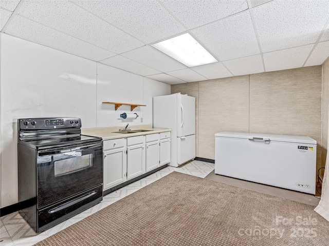 kitchen featuring white cabinets, white refrigerator, sink, black electric range oven, and fridge