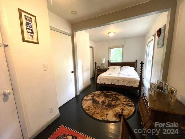 bedroom with dark wood-type flooring and a closet