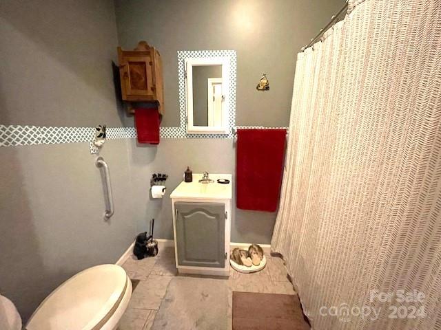 bathroom featuring curtained shower, tile patterned flooring, toilet, and vanity