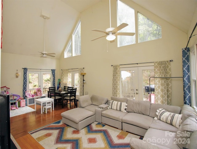 living room with hardwood / wood-style flooring, ceiling fan, high vaulted ceiling, and french doors