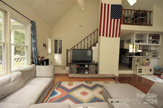 living room featuring plenty of natural light, wood-type flooring, and high vaulted ceiling