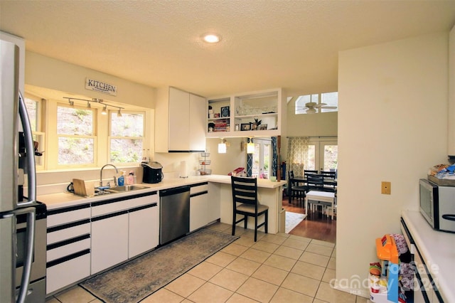 kitchen featuring a healthy amount of sunlight, white cabinetry, sink, and appliances with stainless steel finishes