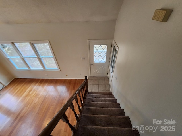 stairs featuring hardwood / wood-style floors