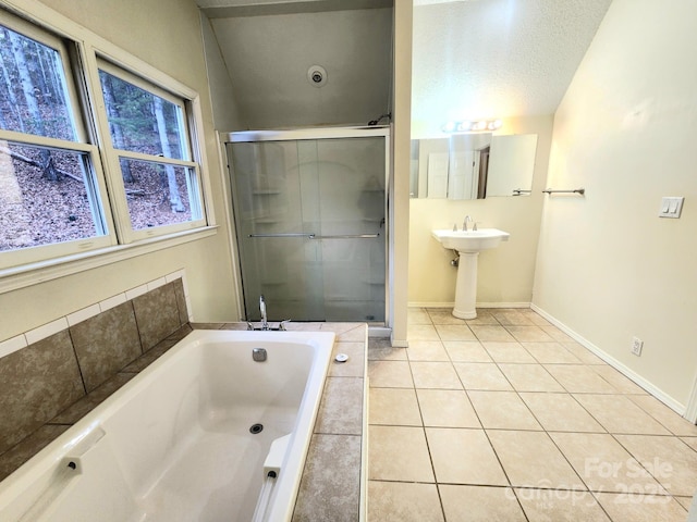 bathroom featuring sink, plus walk in shower, tile patterned flooring, and a textured ceiling