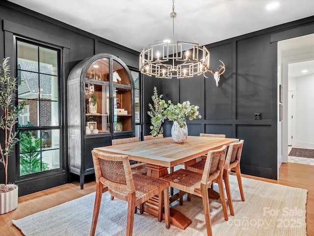 dining room with light wood-type flooring and a notable chandelier