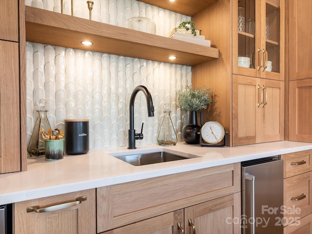 kitchen with sink, light brown cabinets, and tasteful backsplash