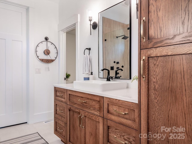 bathroom with tile patterned flooring, walk in shower, and vanity