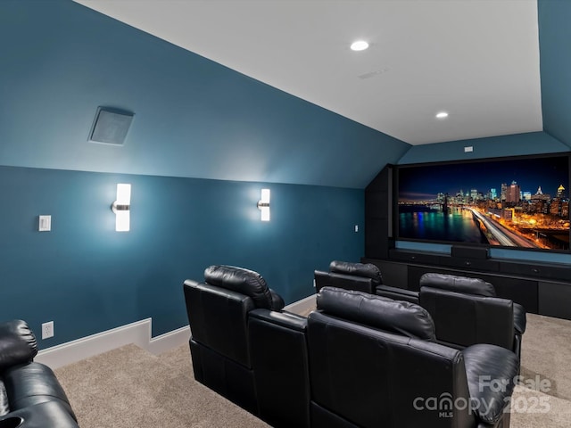 carpeted home theater room with vaulted ceiling