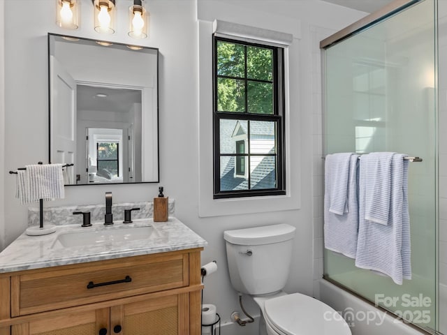 full bathroom with toilet, enclosed tub / shower combo, and vanity