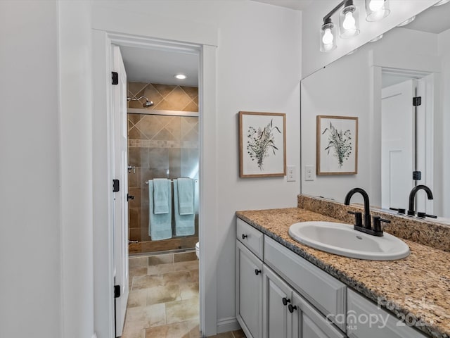 bathroom with walk in shower, vanity, and toilet