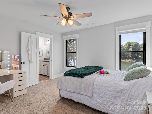 carpeted bedroom featuring ceiling fan, sink, and ensuite bathroom