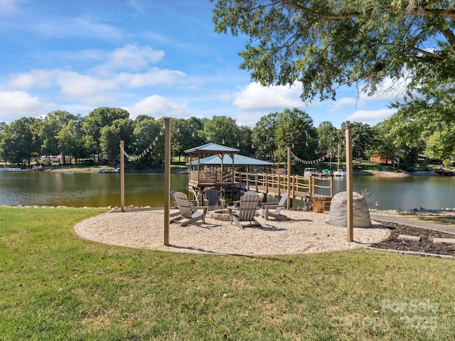 view of jungle gym featuring a gazebo, a yard, a fire pit, and a water view