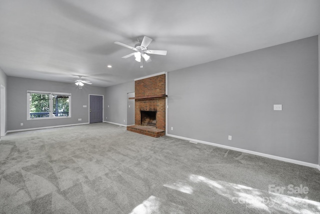 unfurnished living room featuring light carpet, a brick fireplace, and ceiling fan