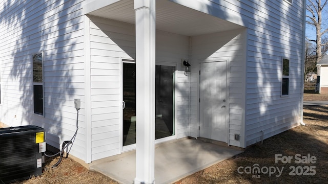 entrance to property featuring central AC unit and a patio area