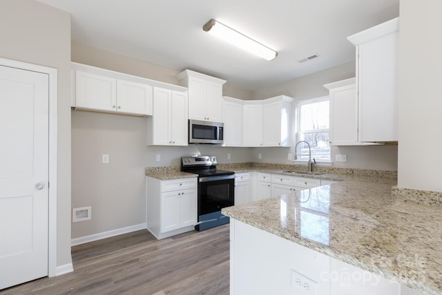 kitchen featuring white cabinets, sink, light wood-type flooring, appliances with stainless steel finishes, and light stone counters