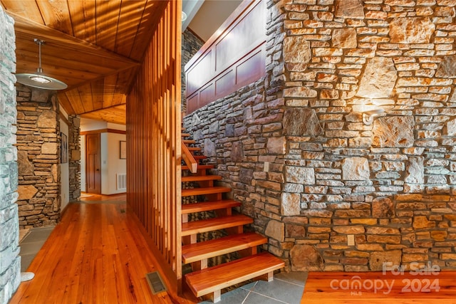 staircase with hardwood / wood-style floors, high vaulted ceiling, and wooden ceiling