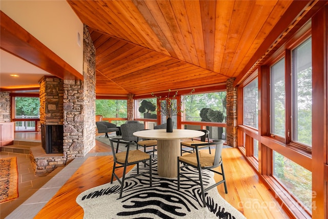 sunroom featuring a fireplace, plenty of natural light, vaulted ceiling, and wooden ceiling