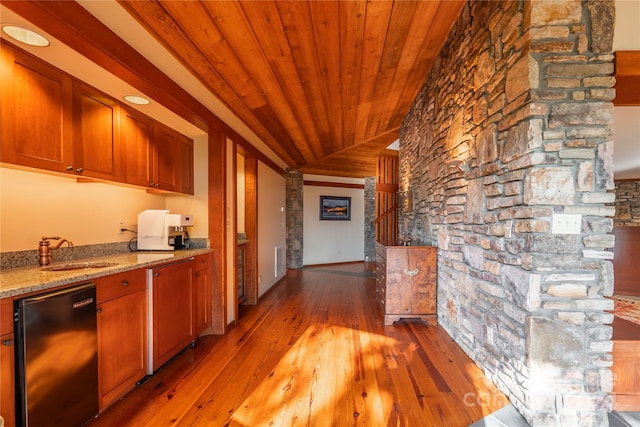 interior space with wooden ceiling, sink, light stone counters, light hardwood / wood-style flooring, and decorative columns