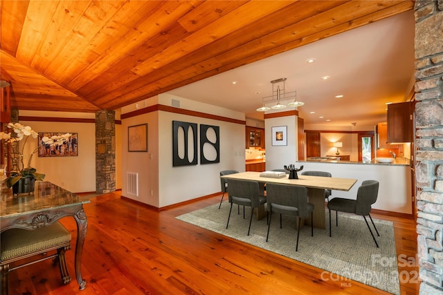 dining space with hardwood / wood-style floors, wood ceiling, ornate columns, and lofted ceiling