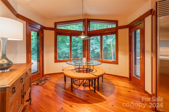 dining space with lofted ceiling, light hardwood / wood-style floors, and plenty of natural light