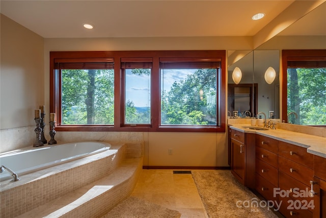 bathroom featuring vanity, tiled bath, and tile patterned floors