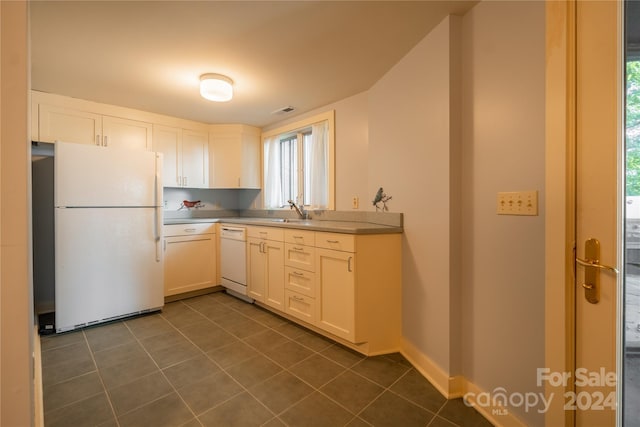 kitchen featuring white cabinetry, dark tile patterned flooring, visible vents, and white appliances