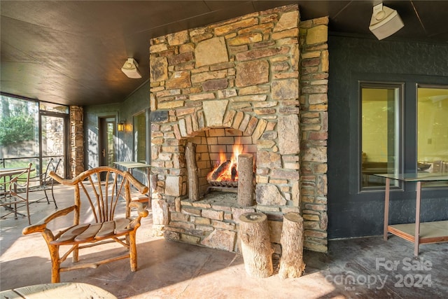 living room with concrete floors and an outdoor stone fireplace