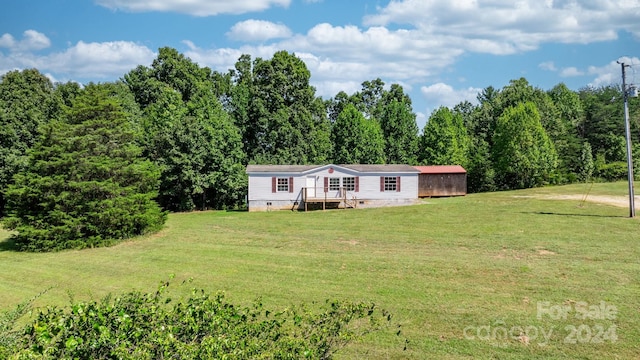 manufactured / mobile home featuring a front lawn and a wooden deck