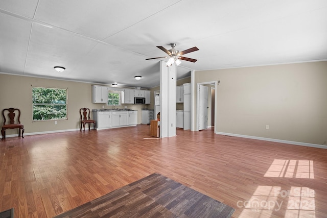 unfurnished living room featuring ceiling fan, light hardwood / wood-style floors, and sink