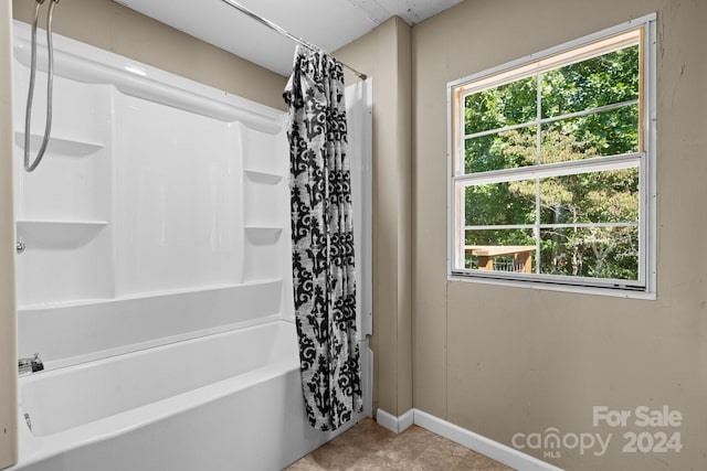 bathroom featuring plenty of natural light and shower / tub combo with curtain