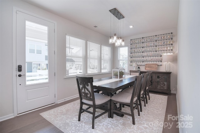 dining area featuring hardwood / wood-style flooring and an inviting chandelier