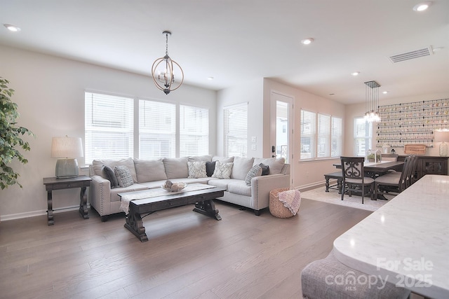 living room with an inviting chandelier and dark wood-type flooring