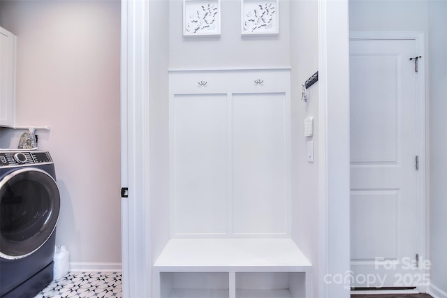 clothes washing area featuring cabinets and washer / clothes dryer