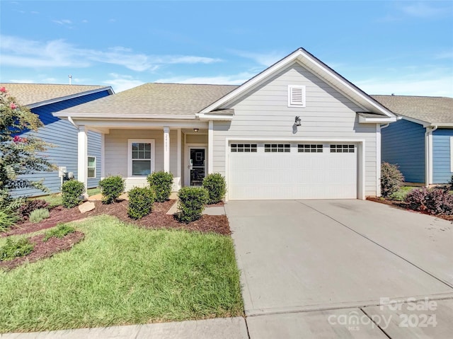 view of front of home featuring a garage, concrete driveway, and roof with shingles