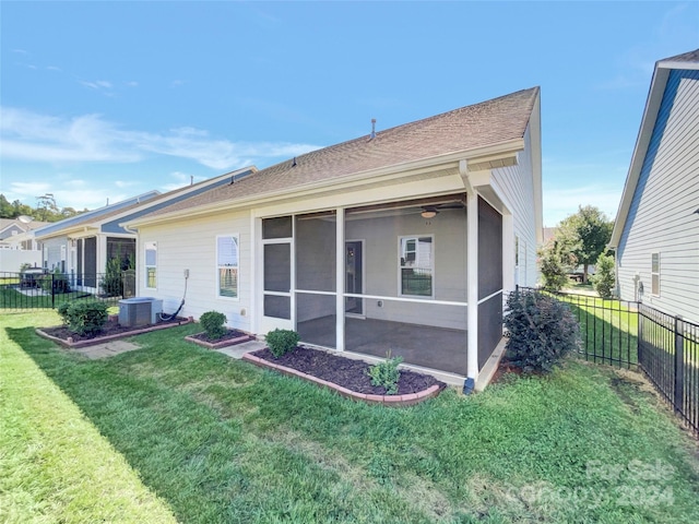 back of property with a sunroom, fence, a lawn, and central AC